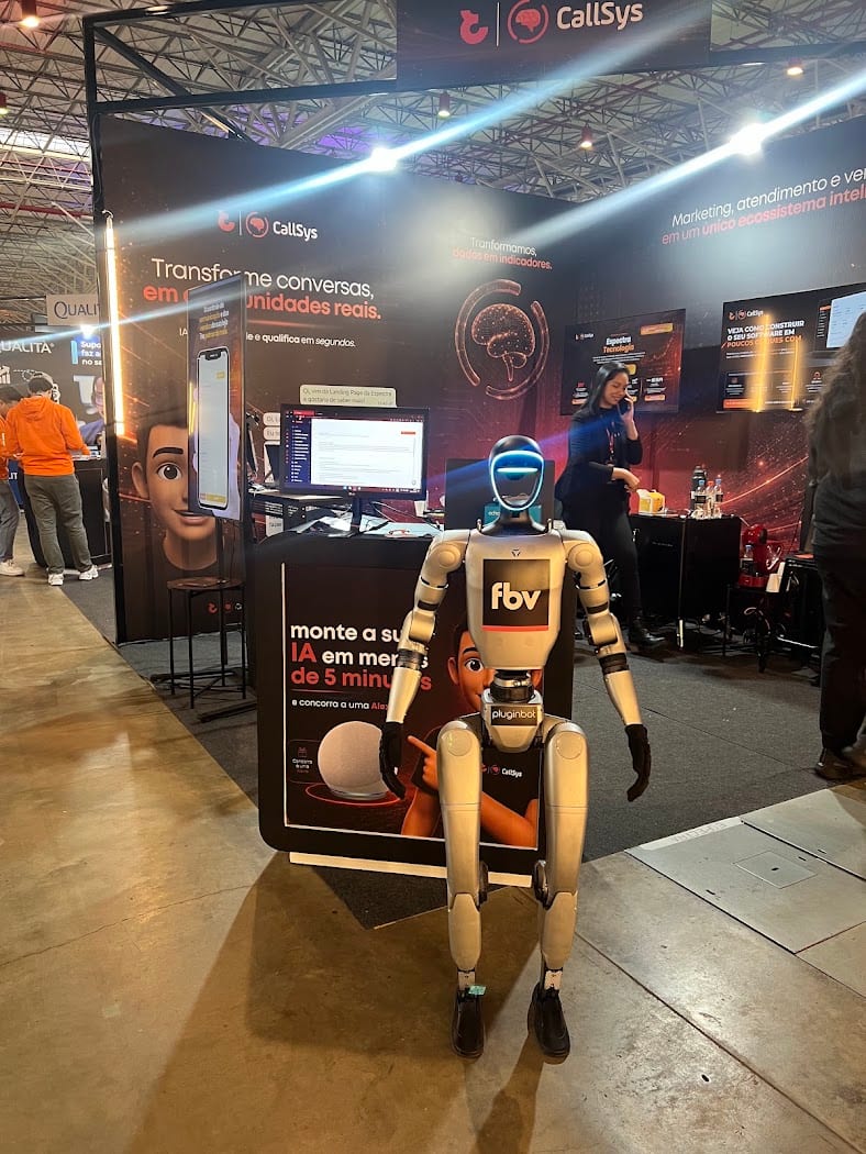 Stand do CallSys na FBV 2026, com o robô e o cartaz da dinâmica "monte a sua IA em menos de 5 minutos"